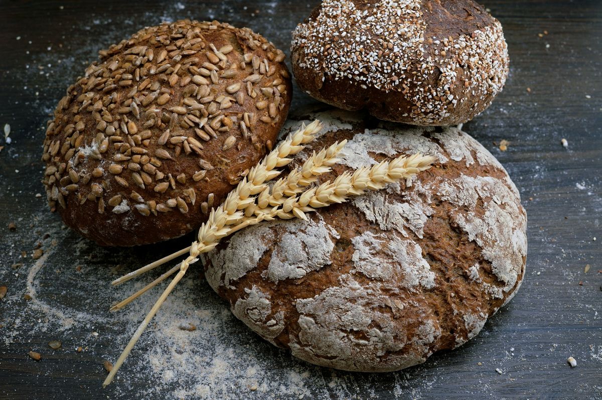Nybakt brød og hvetekorn på trebord